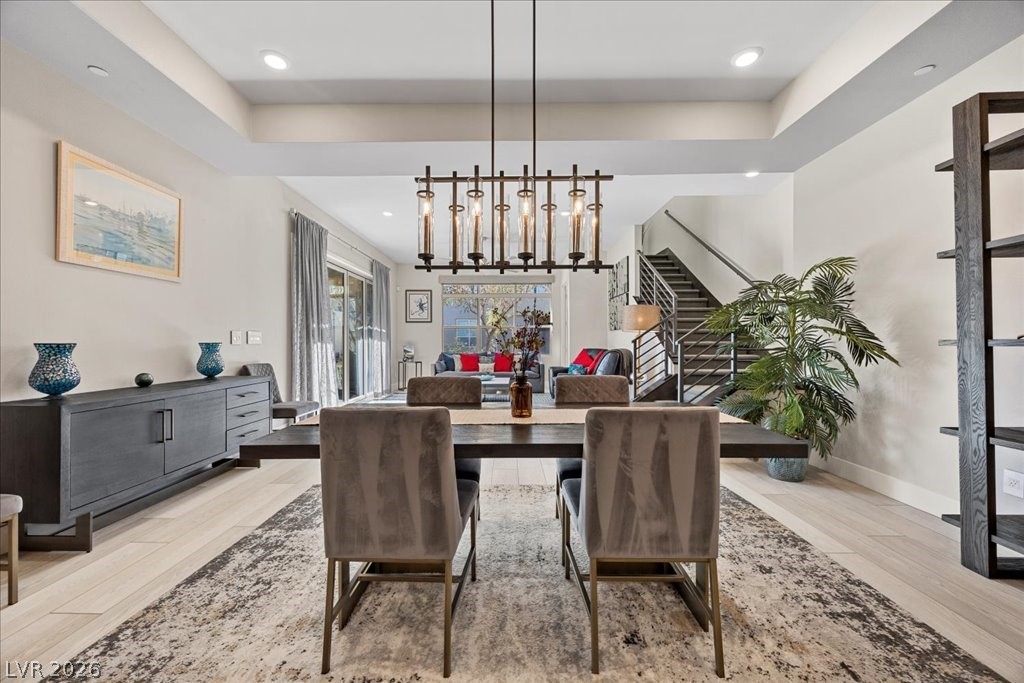 4262 Swift Street Las Vegas, NV 89135 - Photo 15 of 75 Dining area with light wood finished floors, recessed lighting, stairs, and a tray ceiling
