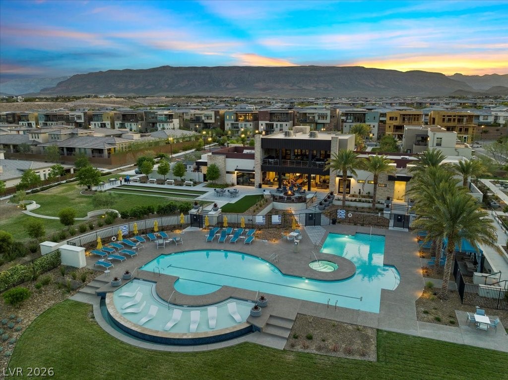 4262 Swift Street Las Vegas, NV 89135 - Photo 54 of 75 Pool at dusk with a community pool, a patio, a mountain view, and a community hot tub