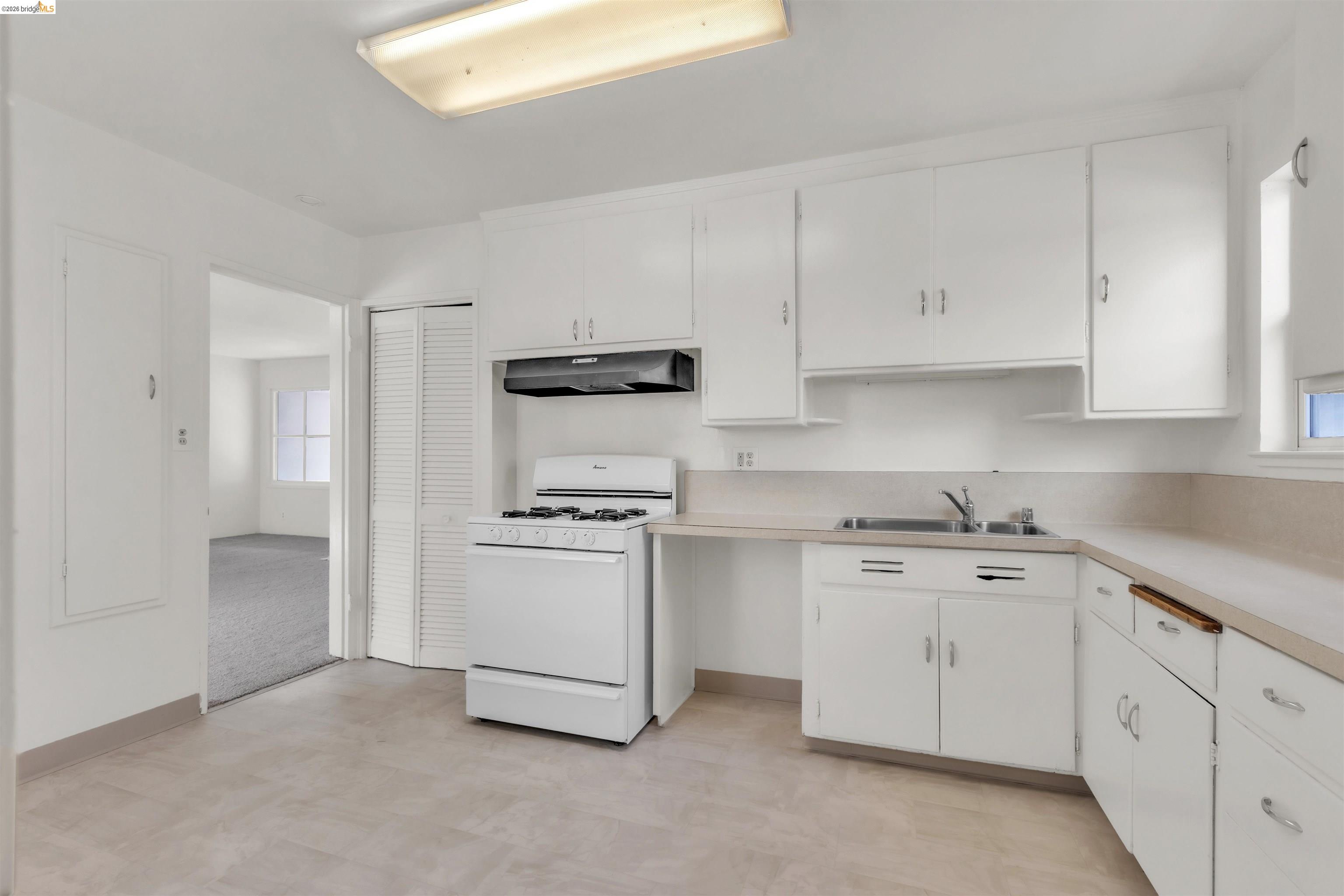 621 Paseo Del Rio San Lorenzo, CA 94580 - Photo 6 of 24 Kitchen featuring white cabinetry, a white gas range, and a dual-basin stainless steel sink