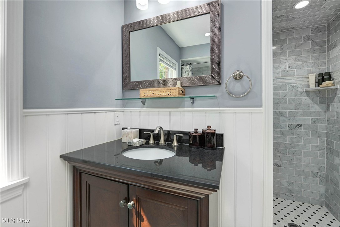 4022 Hillbrook Road Cleveland, OH 44118 - Photo 25 of 49 Bathroom featuring a stall shower, vanity, and a wainscoted wall