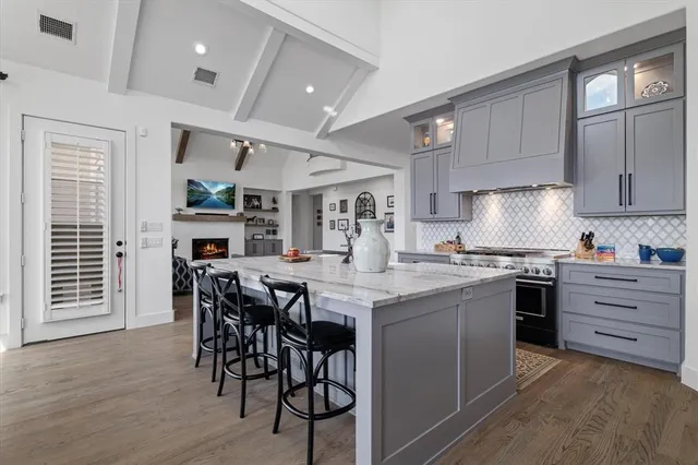 a kitchen with stainless steel appliances kitchen island granite countertop a table chairs sink and cabinets