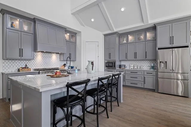 a kitchen with a dining table chairs refrigerator and cabinets
