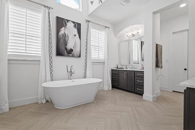 a bathroom with a tub sink and mirror