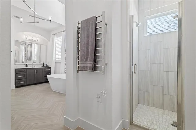 a bathroom with a tub a sink and mirror