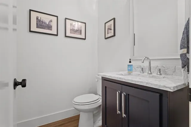a bathroom with a granite countertop sink a toilet and a mirror