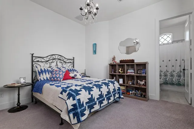 a bedroom with a bed chandelier and a window