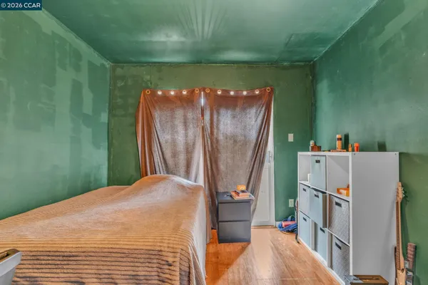 a bedroom with a bed and a refrigerator