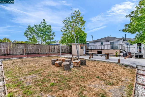 a view of a patio with table and chairs and potted plants with wooden fence