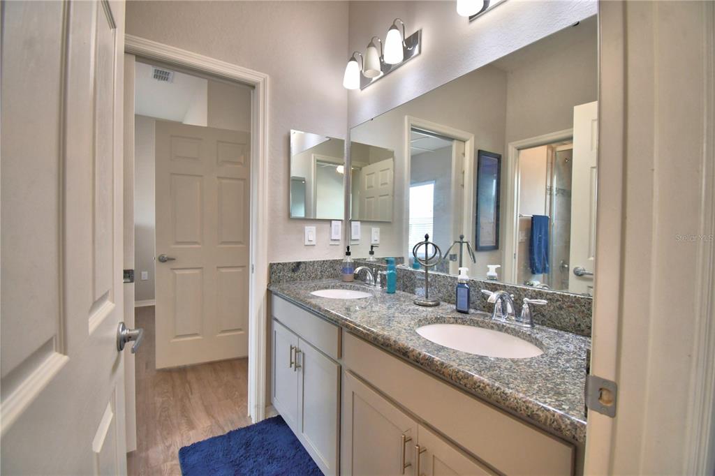 4340 Reding Way Lakeland, FL 33813 - Photo 30 of 63 a bathroom with a granite countertop double vanity sink a mirror and a shower