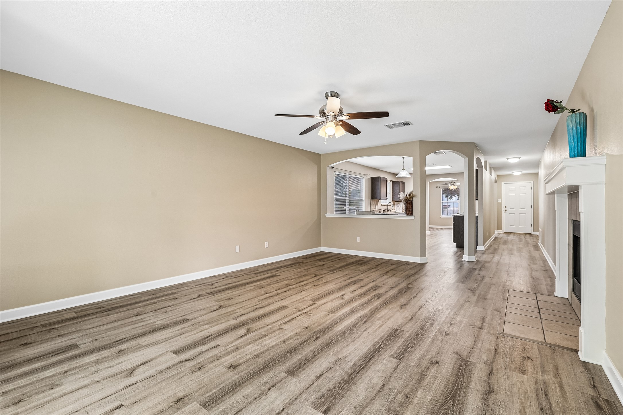 152 Grant Way Kyle, TX 78640 - Photo 13 of 39 a view of a livingroom with wooden floor and a ceiling fan
