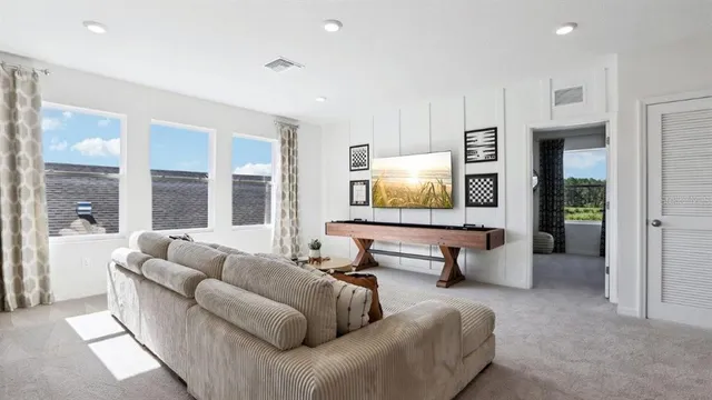 a living room with furniture and large windows