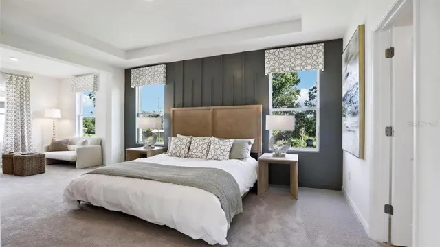 a bedroom with a bed couch and a large window