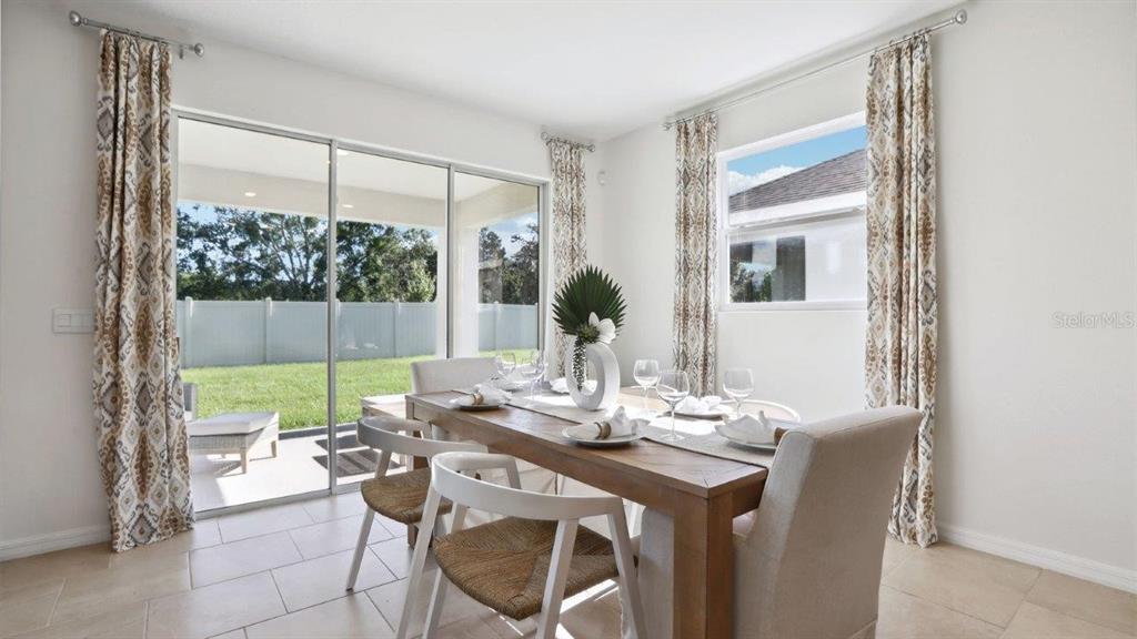 2425 Stratten Drive Zephyrhills, FL 33541 - Photo 9 of 28 a dining room with furniture a chandelier and wooden floor
