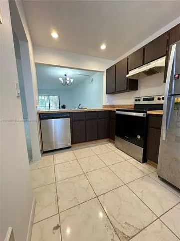 a large kitchen with stainless steel appliances a sink and a counter top space