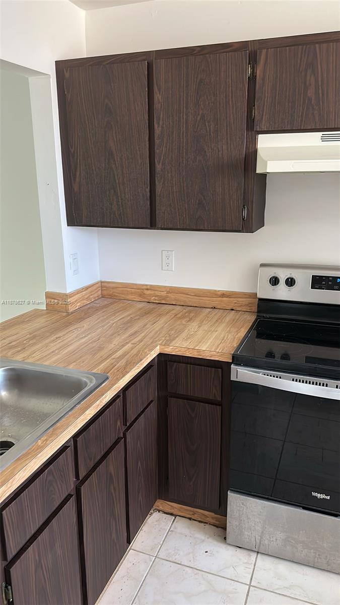 861 Northeast 209th Terrace, Unit 203 Miami, FL 33179 - Photo 4 of 16 a kitchen with a sink and cabinets