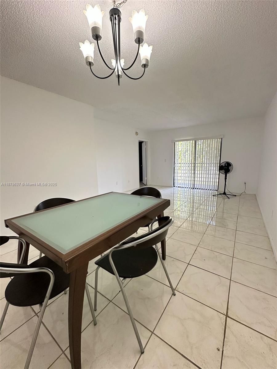 861 Northeast 209th Terrace, Unit 203 Miami, FL 33179 - Photo 5 of 16 a room with a table and chairs