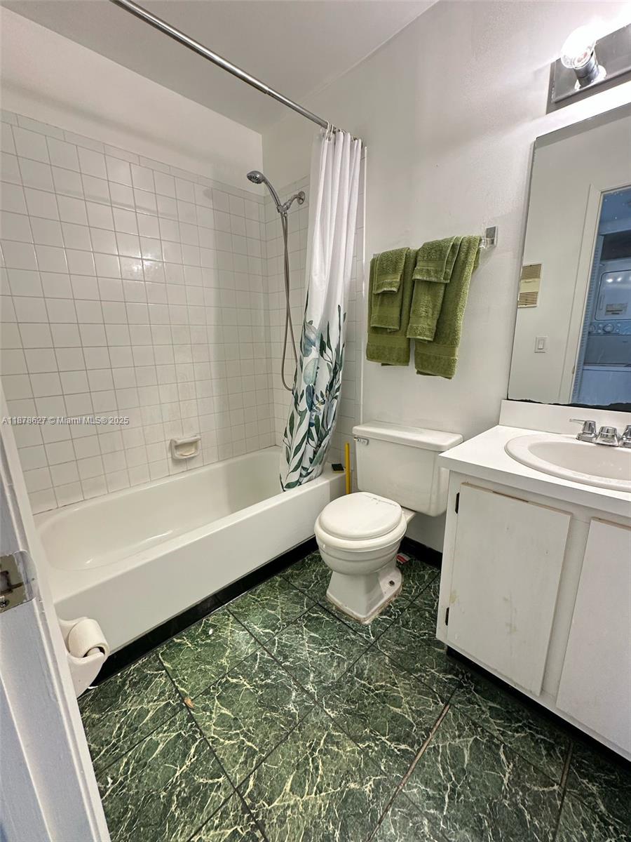 861 Northeast 209th Terrace, Unit 203 Miami, FL 33179 - Photo 9 of 16 a bathroom with a toilet and a bathtub