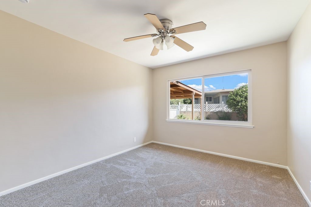 14802 Springford Drive La Mirada, CA 90638 - Photo 13 of 26 an empty room with a window and a ceiling fan