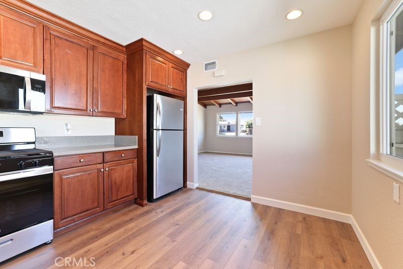 14802 Springford Drive La Mirada, CA 90638 - Photo 8 of 26 a kitchen with granite countertop wooden floors and stainless steel appliances