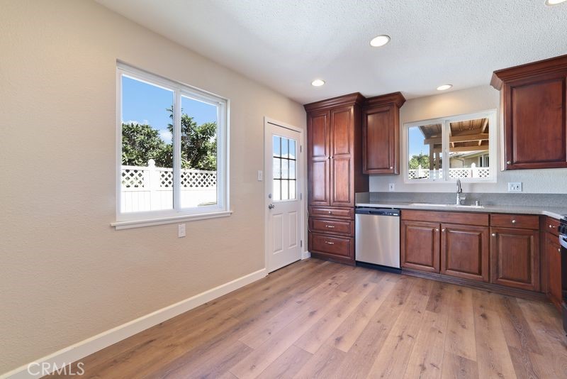 14802 Springford Drive La Mirada, CA 90638 - Photo 9 of 26 a kitchen with stainless steel appliances granite countertop a sink cabinets and wooden floor
