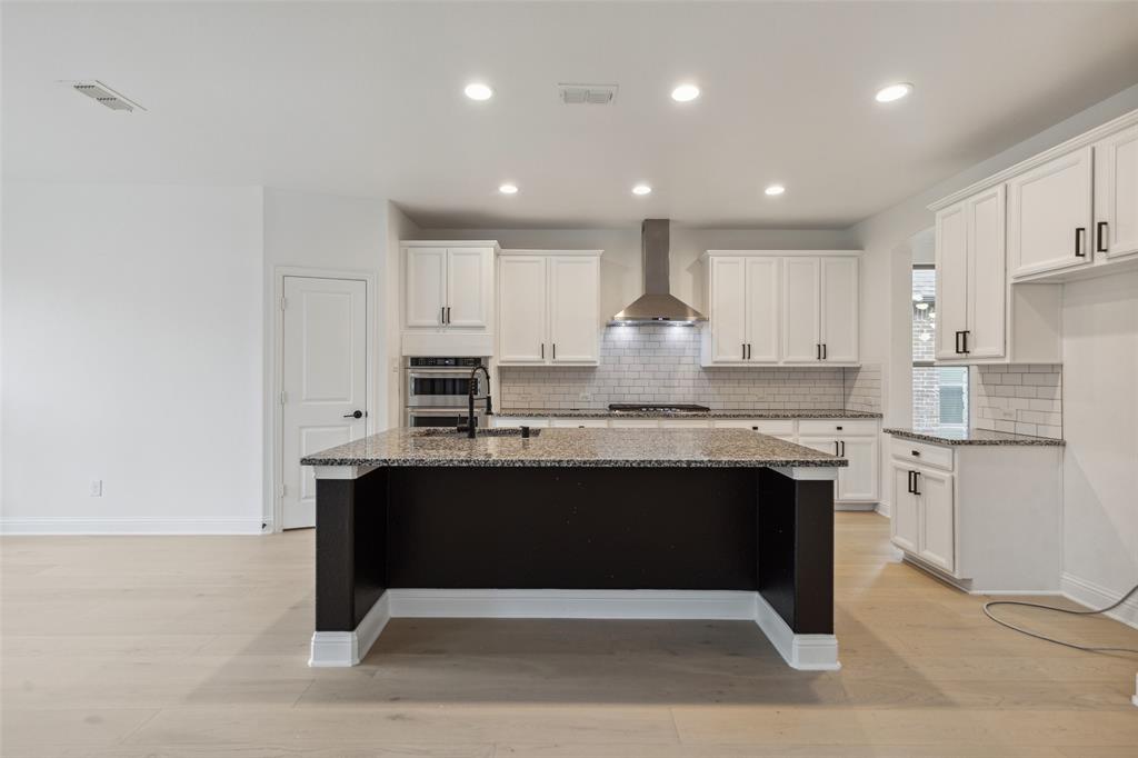 3737 Nottingham The Colony, TX 75056 - Photo 9 of 34 a kitchen with kitchen island granite countertop a sink cabinets and stainless steel appliances