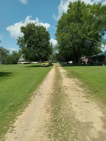 a view of yard with swimming pool and green space