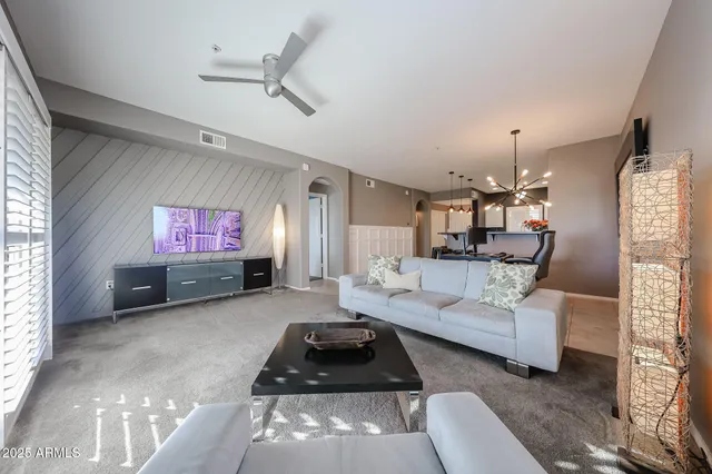 a living room with furniture a rug and a flat screen tv