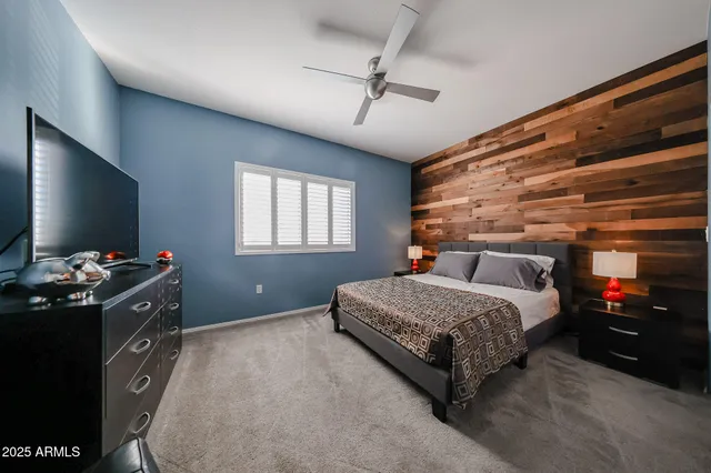 a bedroom with a bed and a flat tv screen on dresser