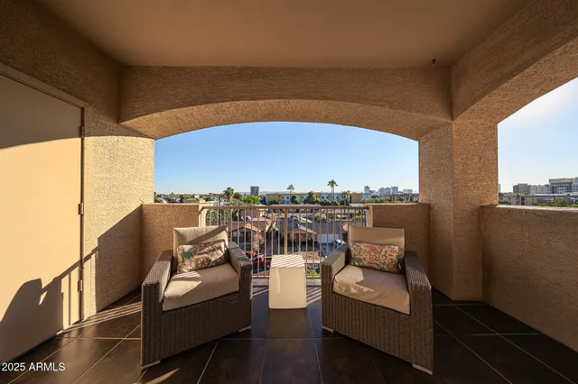 a view of a roof deck with couches under an umbrella