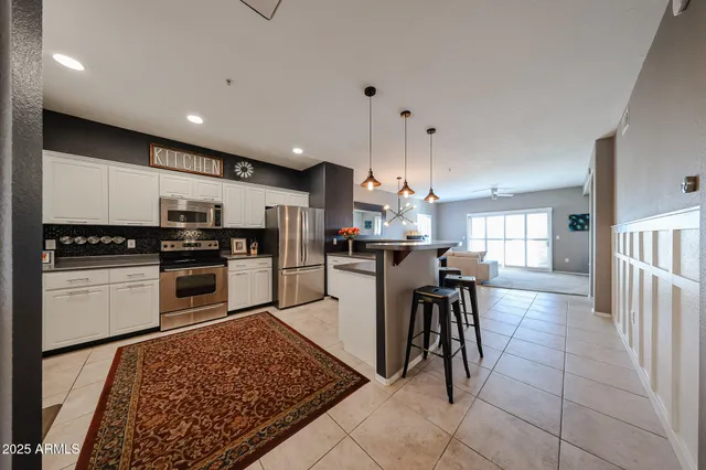 a kitchen with stainless steel appliances kitchen island granite countertop a sink and cabinets