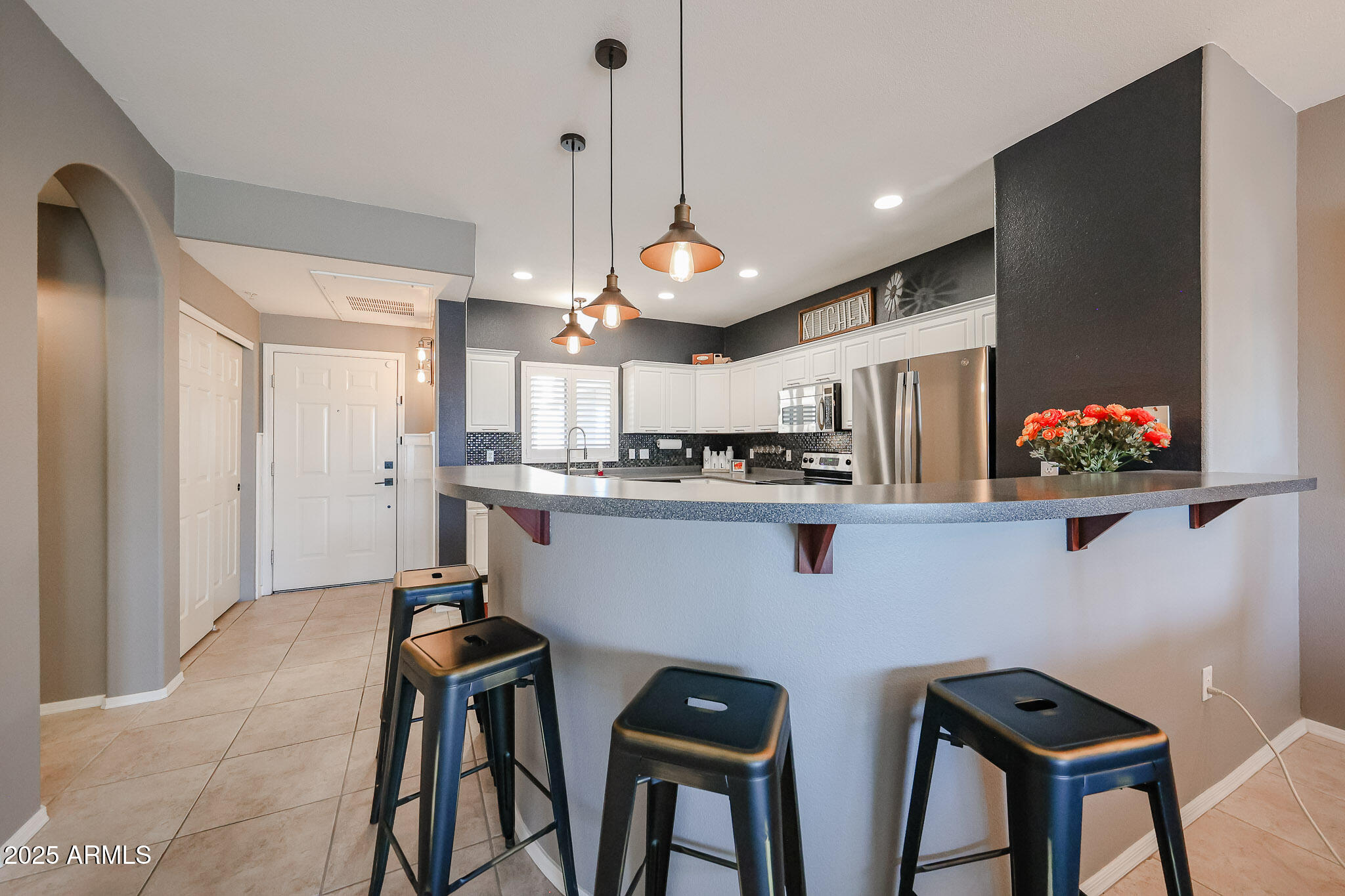 920 East Devonshire Avenue, Unit 4001 Phoenix, AZ 85014 - Photo 7 of 38 a kitchen with stainless steel appliances kitchen island granite countertop a table chairs and a refrigerator