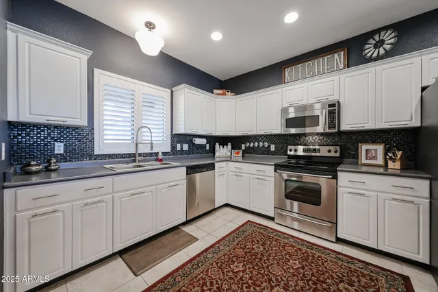 a kitchen with granite countertop a sink a stove and cabinets