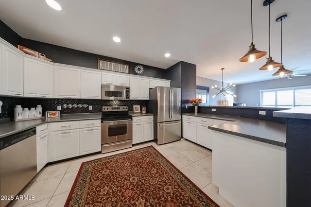 a kitchen with a sink stainless steel appliances and white cabinets