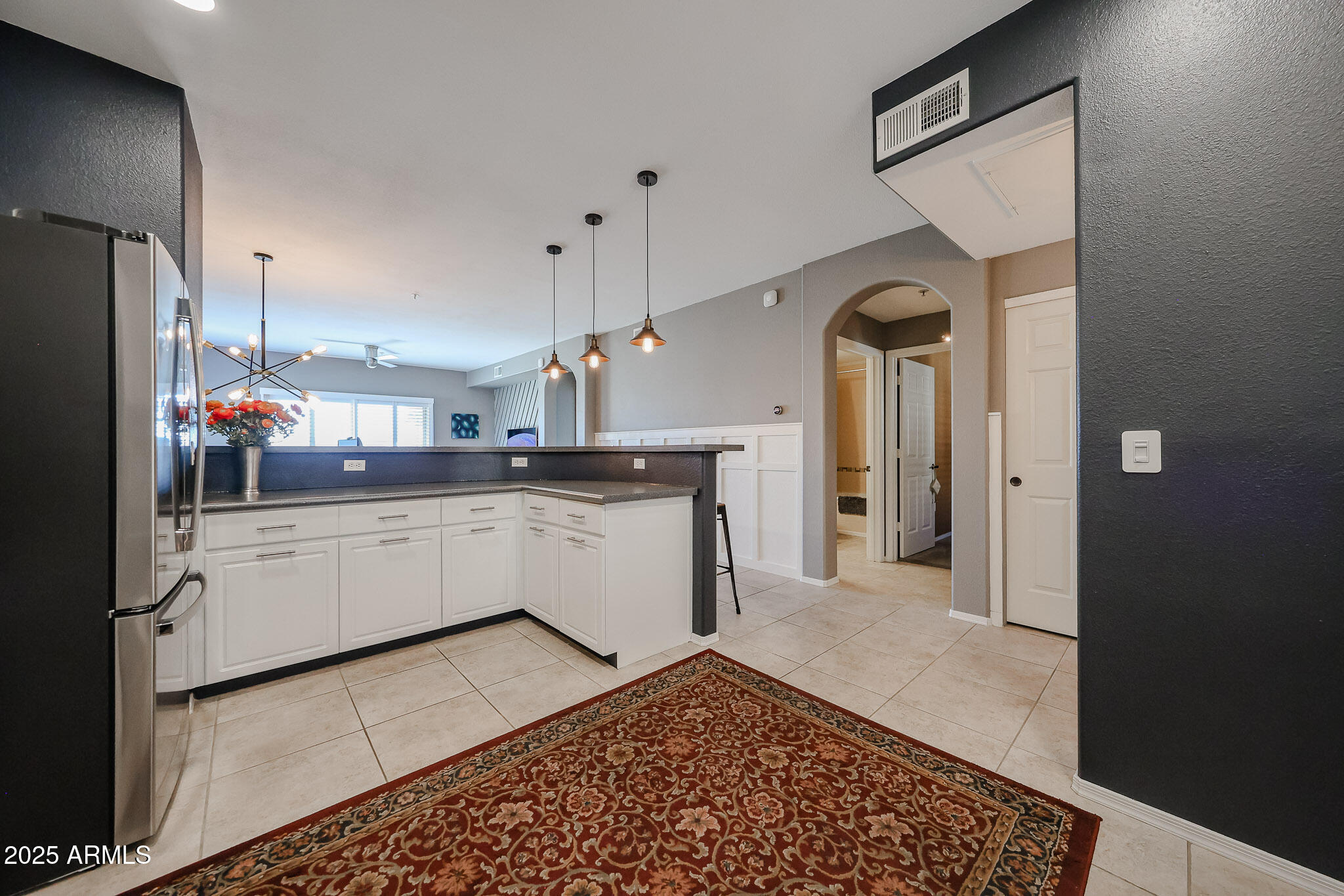 920 East Devonshire Avenue, Unit 4001 Phoenix, AZ 85014 - Photo 10 of 38 a large white kitchen with a refrigerator a sink dishwasher and white cabinets with wooden floor