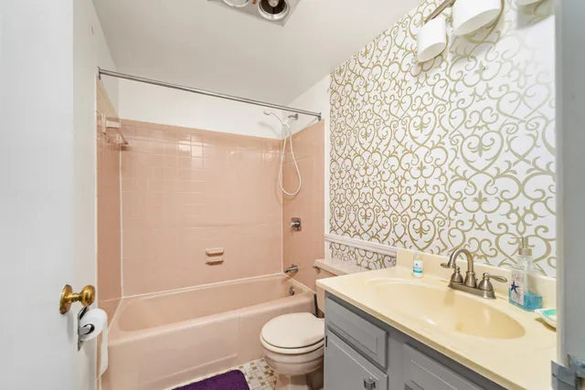 a bathroom with a granite countertop sink toilet and shower