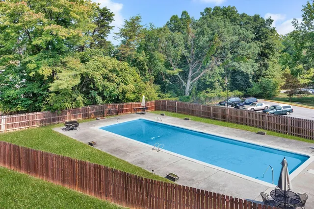 a view of a swimming pool with a patio and yard