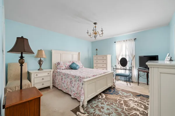 a bedroom with a bed and a chandelier