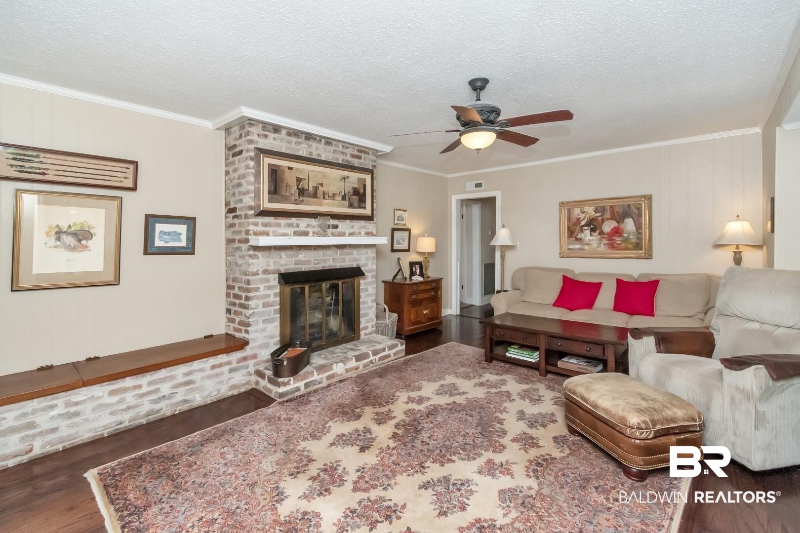 302 Springwood Drive East Mobile, AL 36608 - Photo 11 of 35 Living room featuring dark hardwood / wood-style flooring, ornamental molding, a textured ceiling, ceiling fan, and a fireplace