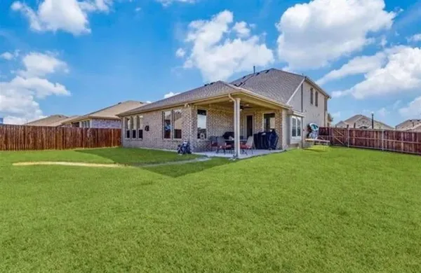 a view of a house with a big yard and large trees
