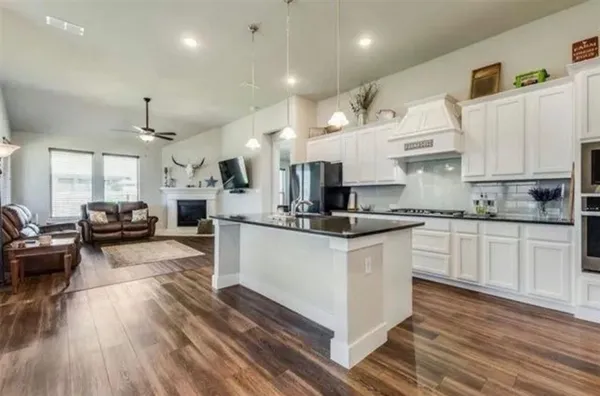 a kitchen with kitchen island granite countertop lots of counter top space and stainless steel appliances