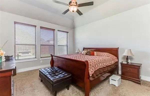 a bedroom with a bed and a window with a dresser