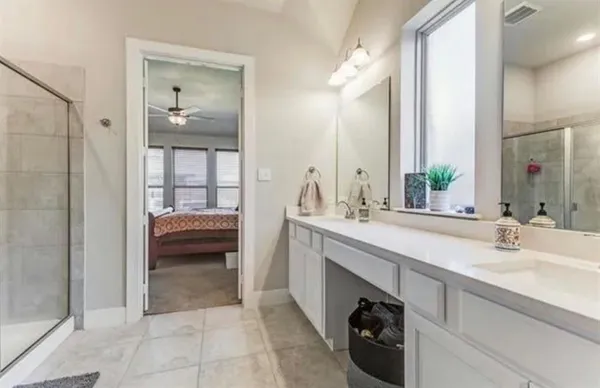 a en suite bathroom with a sink a mirror and a shower