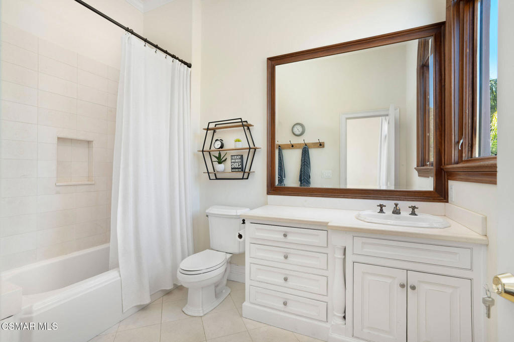 6934 Solano Verde Drive Somis, CA 93066 - Photo 40 of 80 a bathroom with a toilet sink a mirror a shower and vanity