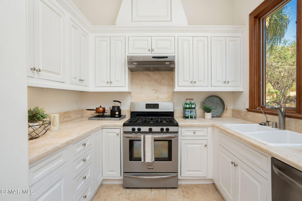 6934 Solano Verde Drive Somis, CA 93066 - Photo 59 of 80 a kitchen with granite countertop white cabinets and white appliances