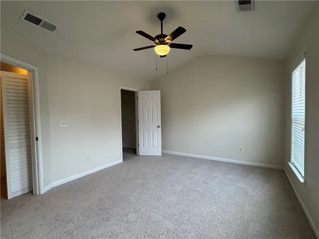 an empty room with a window and a ceiling fan