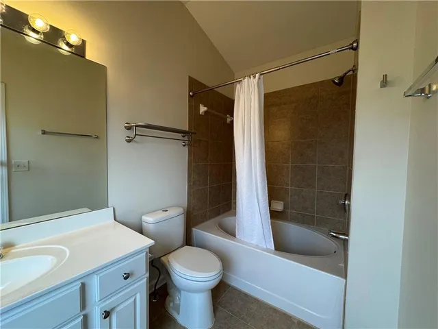 a bathroom with a shower a toilet and a sink