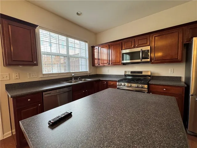 a kitchen with stainless steel appliances a stove microwave and sink