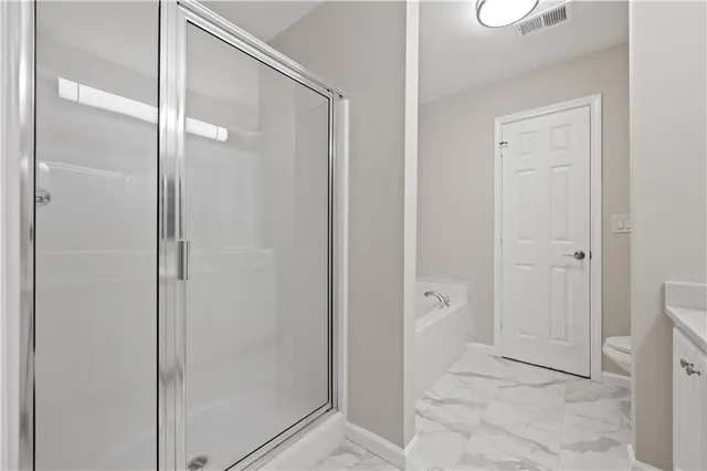 a bathroom with a shower and a glass door
