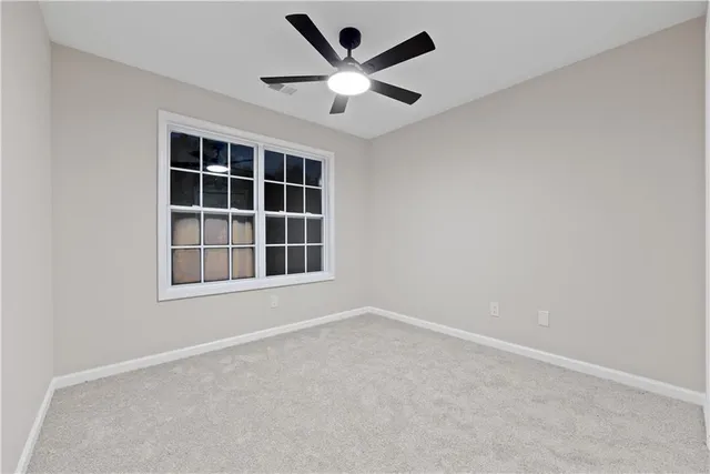 an empty room with a window and a ceiling fan