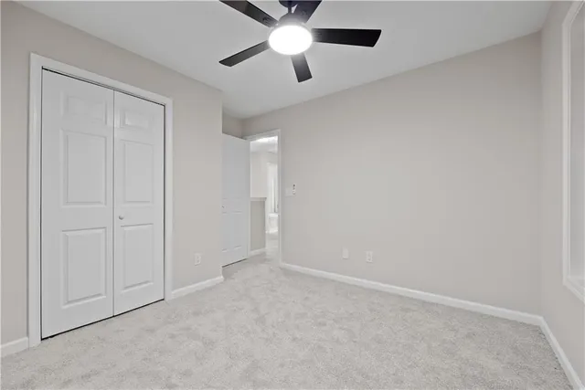 an empty room with closet and a chandelier fan